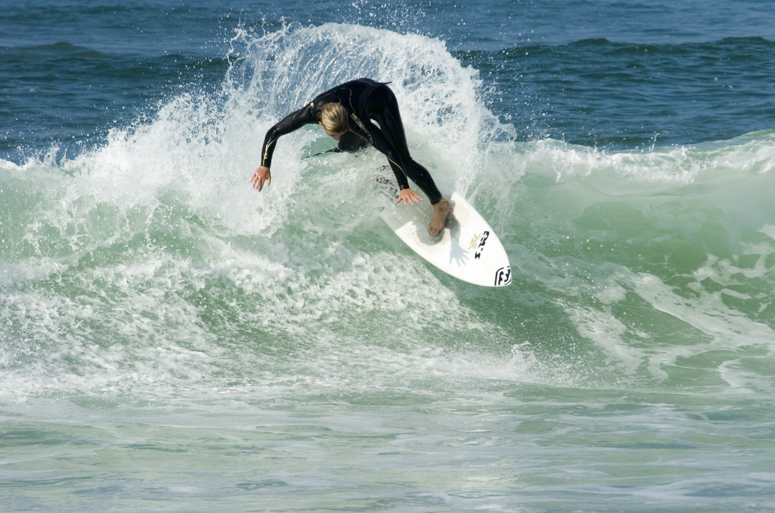 Session surf: un surfeur prend une vague.