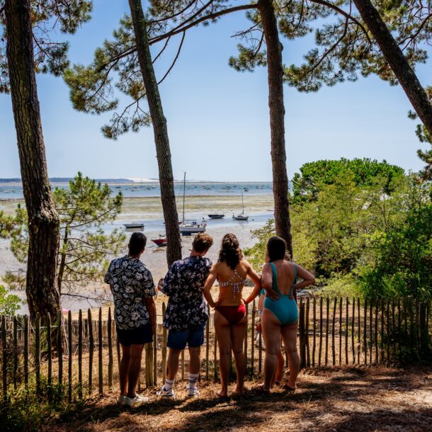 Journée entre amis : un groupe de jeunes contemple le bassin à marée basse.