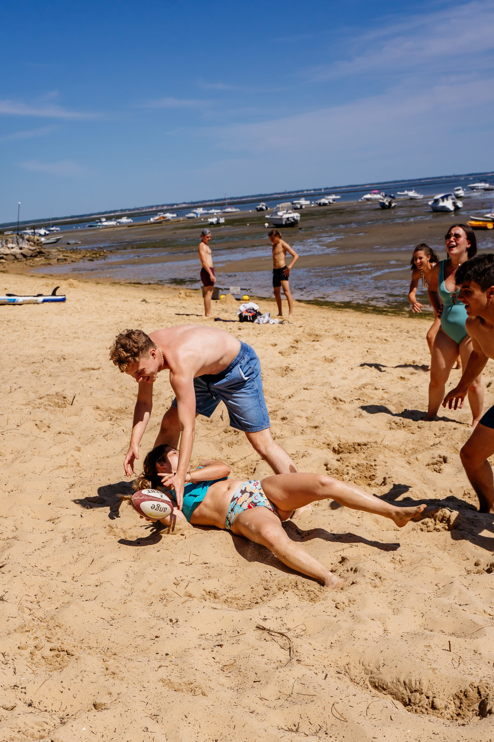 Des enfants s'amusent dans le sable à marée basse.