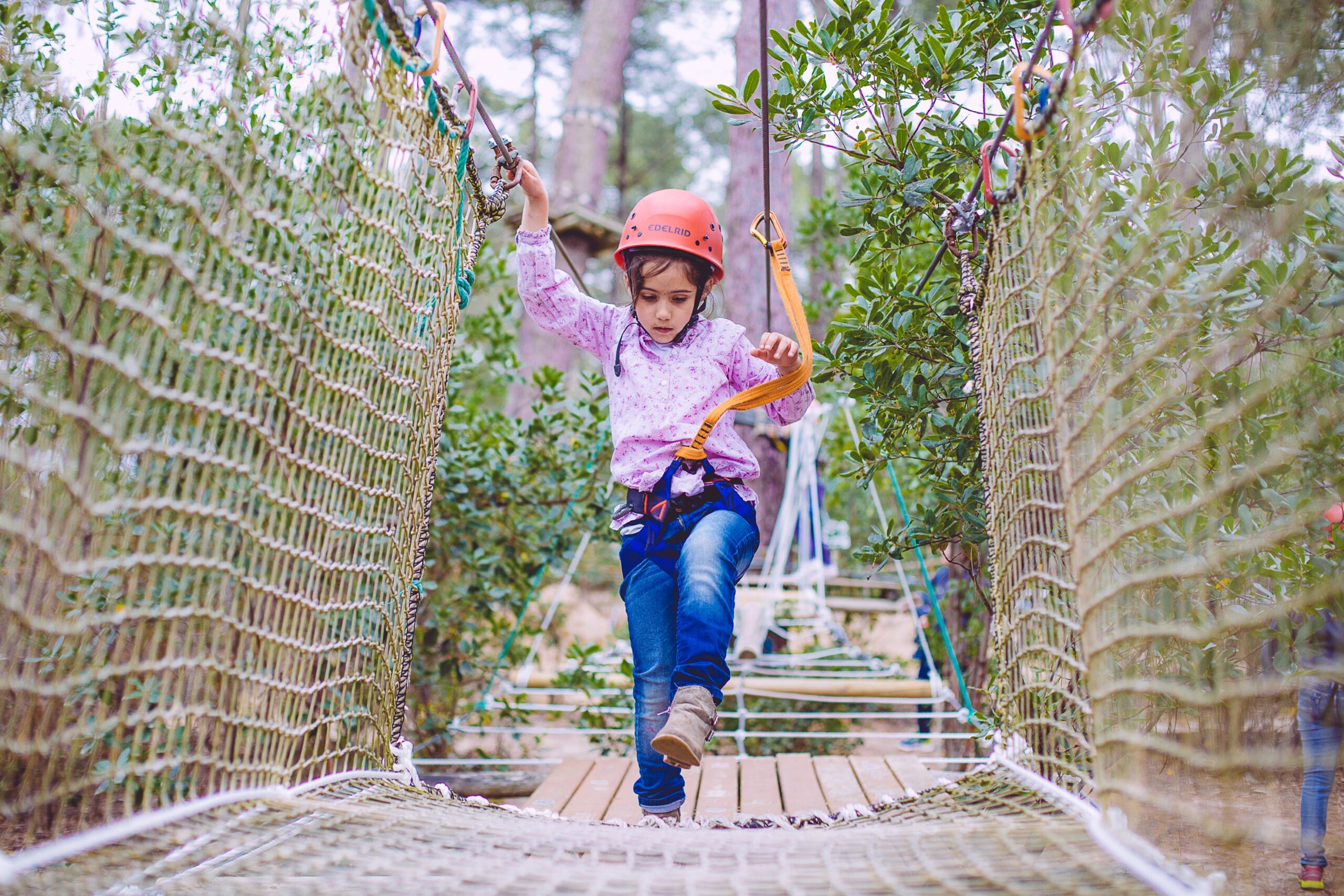 Une fille est à l'accrobranche au Four.