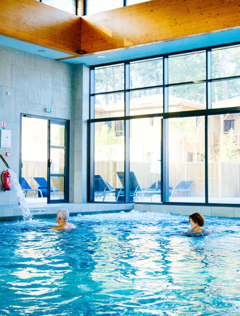 Une femme se détend dans la piscine intérieur au Balneo Serge Blanco à Claouey.