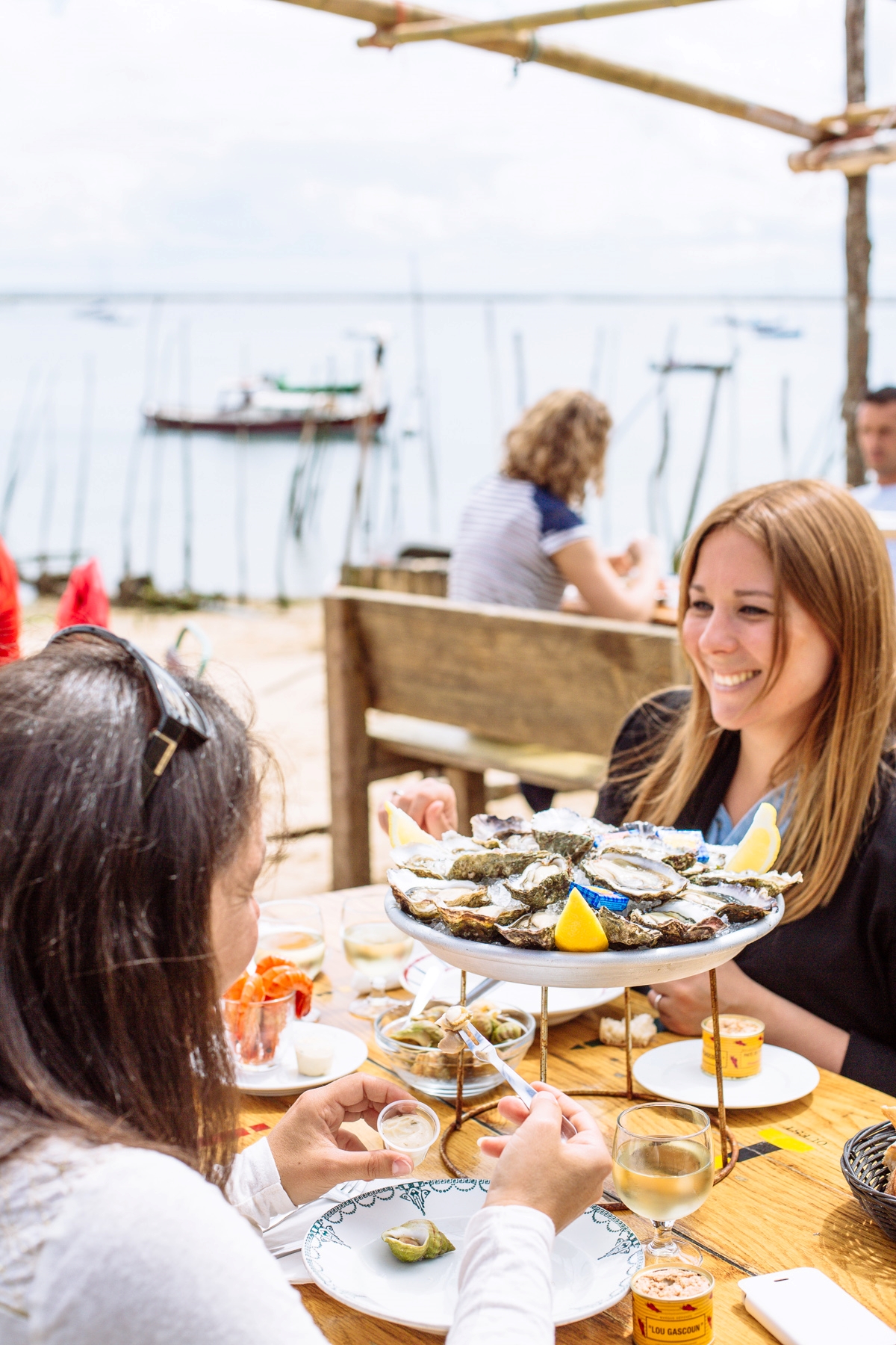 Des femmes sont au restaurant à l'Herbe avec le bassin à l'arrière.