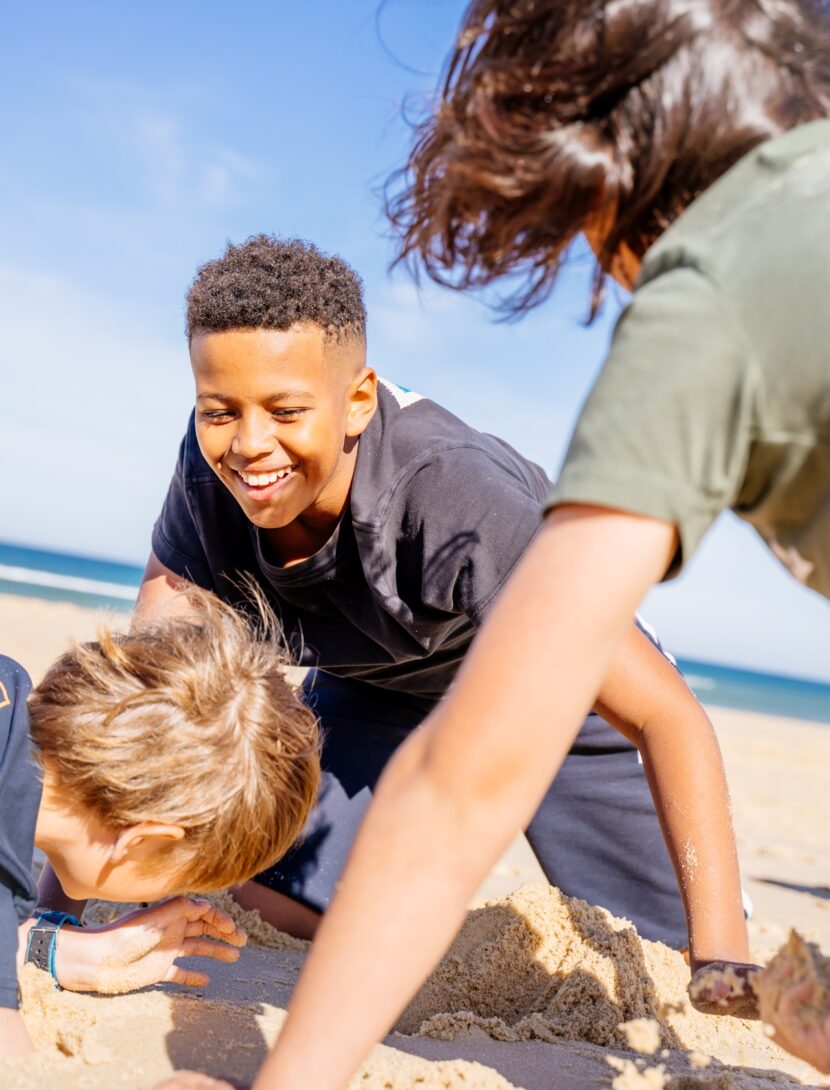 Des enfants s'amusent dans le sable à l'océan.
