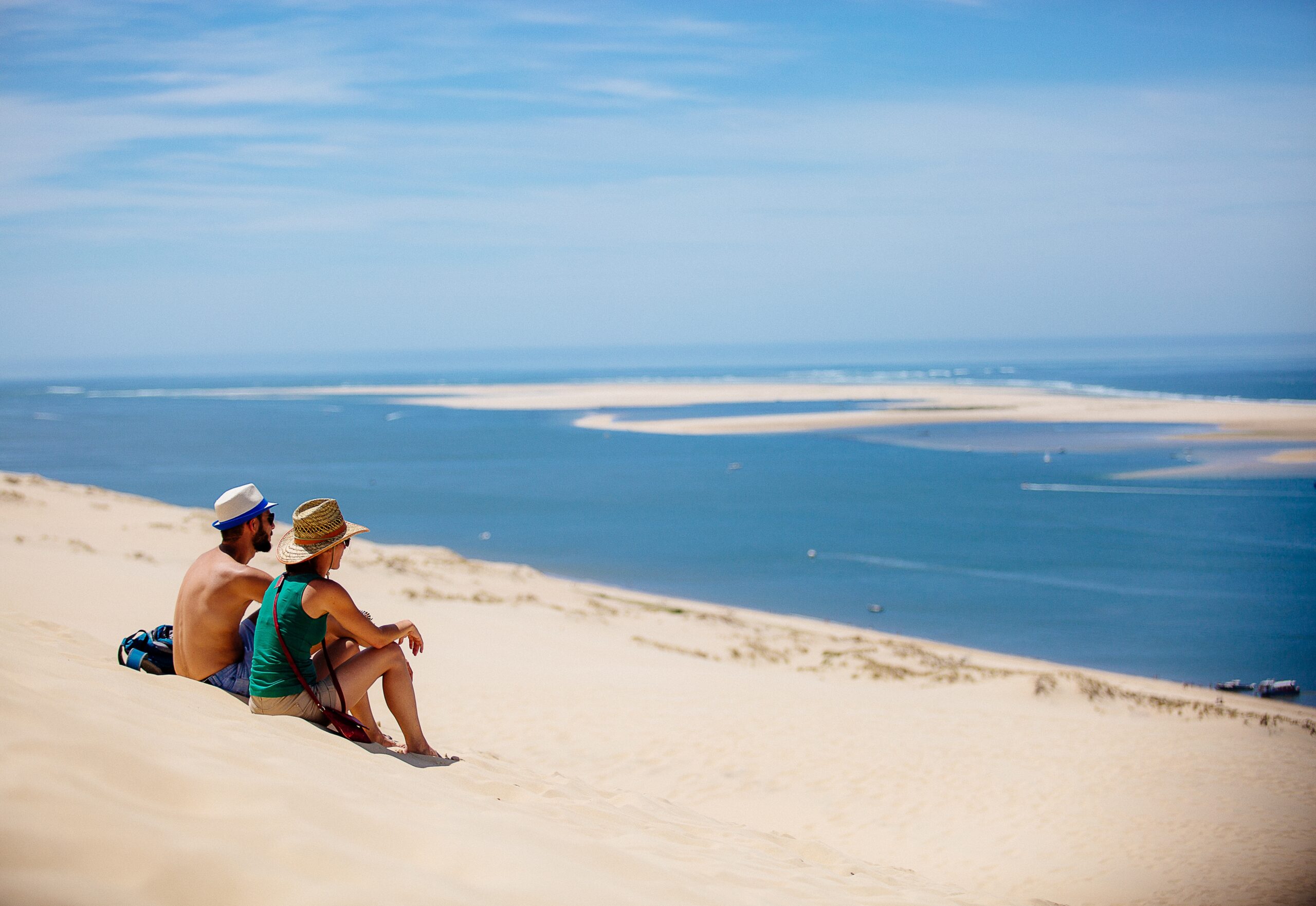 Un couple assis sur la Dune du Pilat contemple le Bassin.