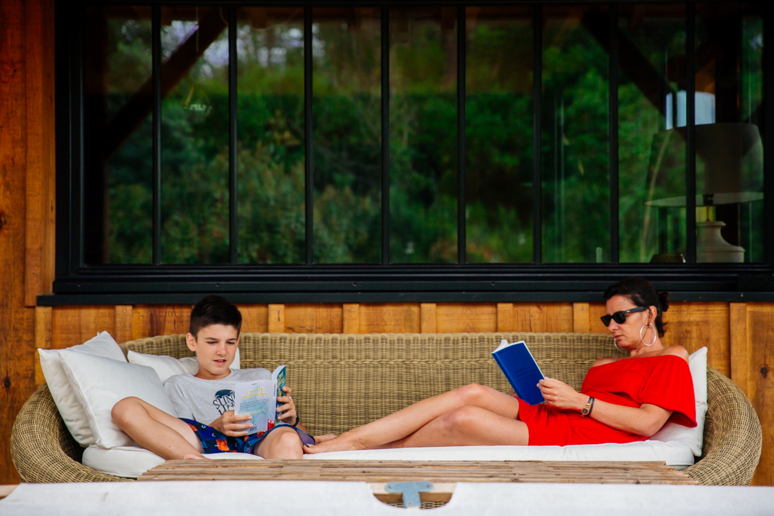 Moment détente, lecture sur une terrasse pour une mère et son fils.