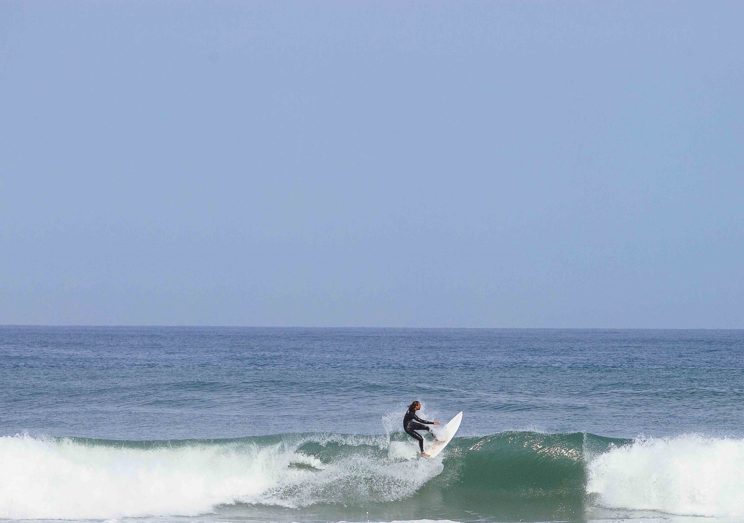 Un surfeur prend un vague.