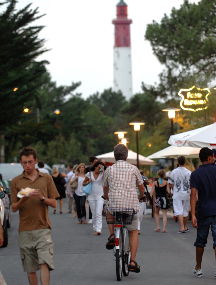 Un marché nocturne pendant l'été au Cap Ferret avec le phare en arrière plan.