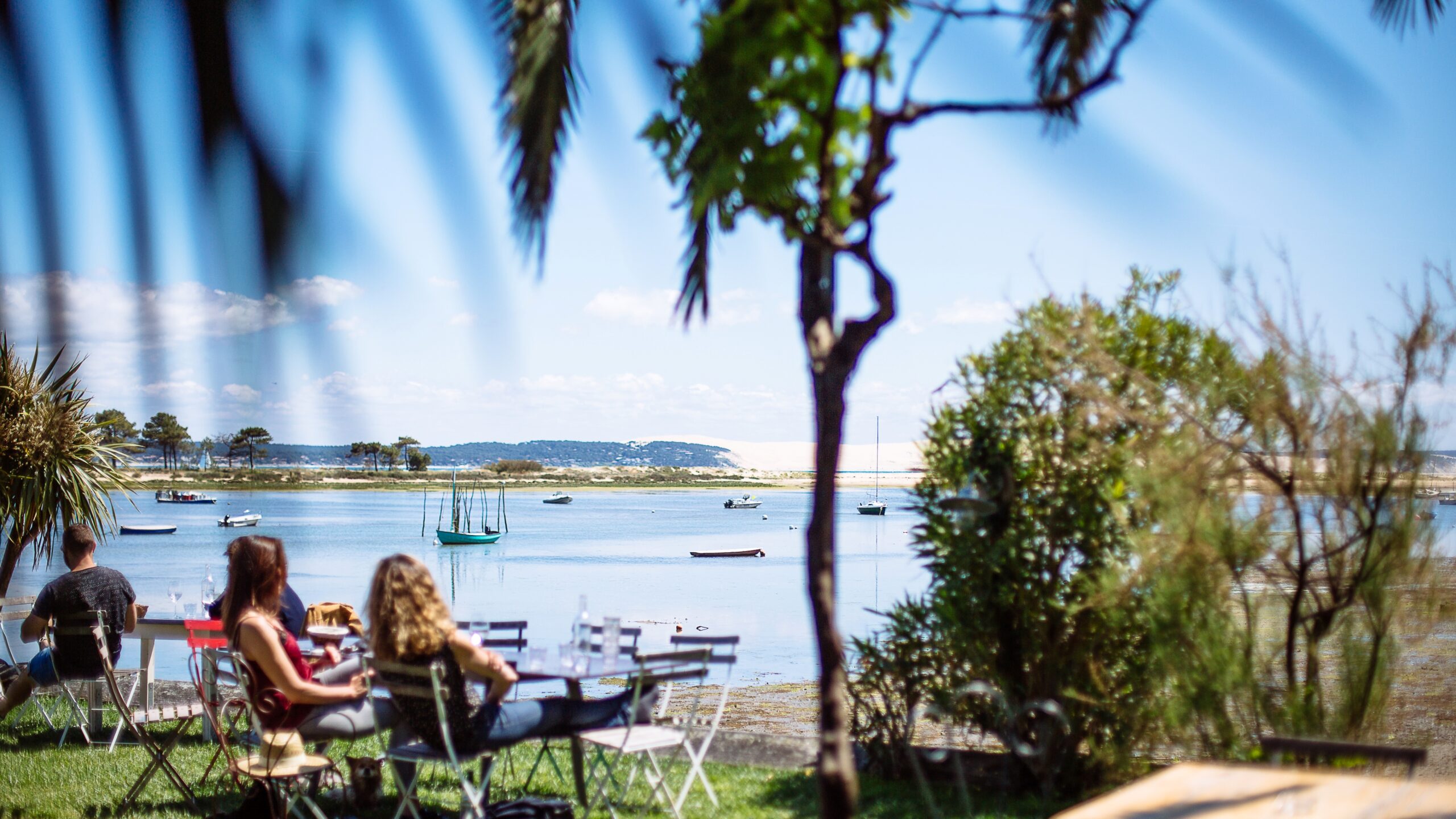 Deux femmes sont sur la terrasse en train de bronzer après leur repas.