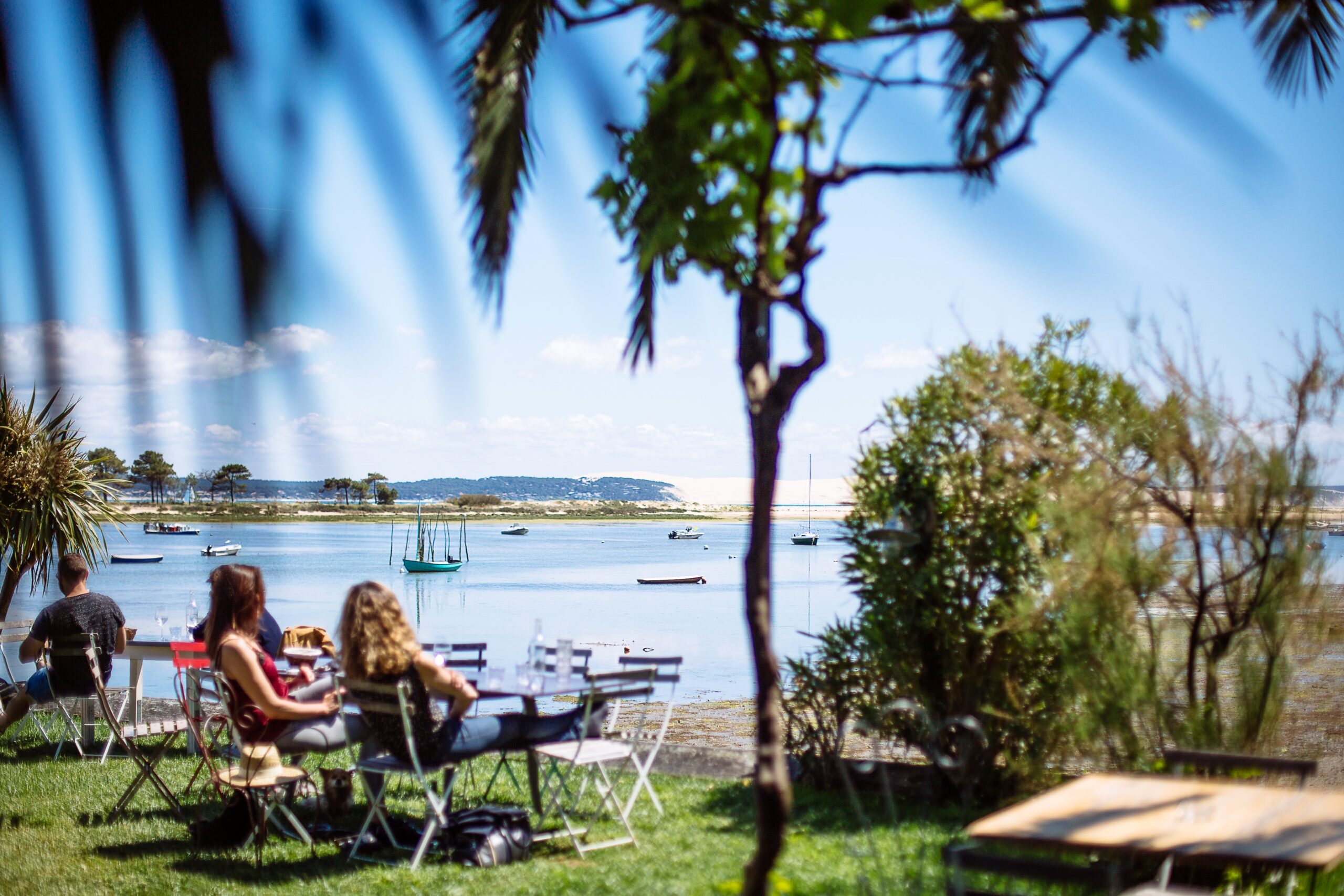 Deux femmes sont sur la terrasse en train de bronzer après leur repas.