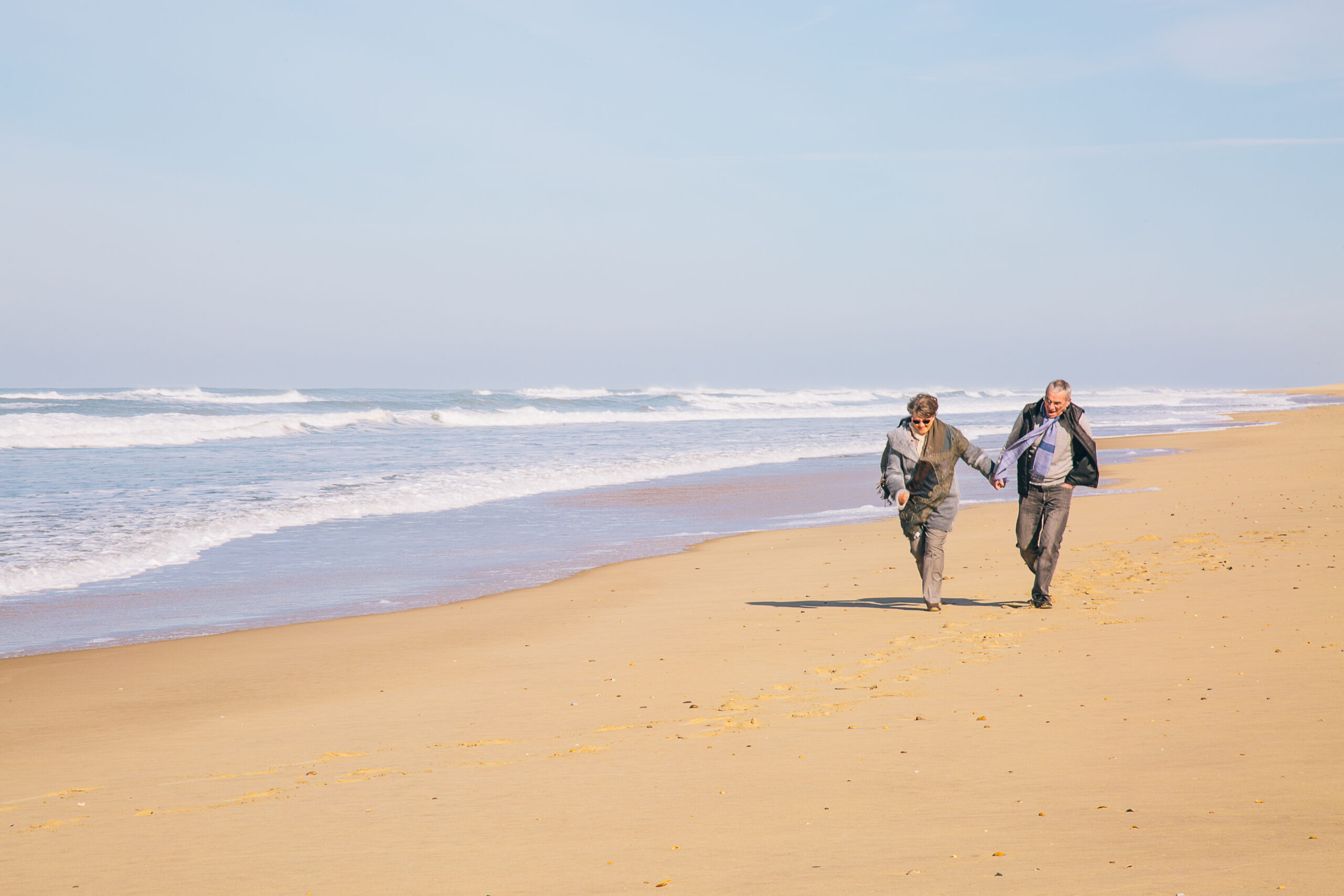 Un couple se promène sur la plage océanique du Cap Ferret.