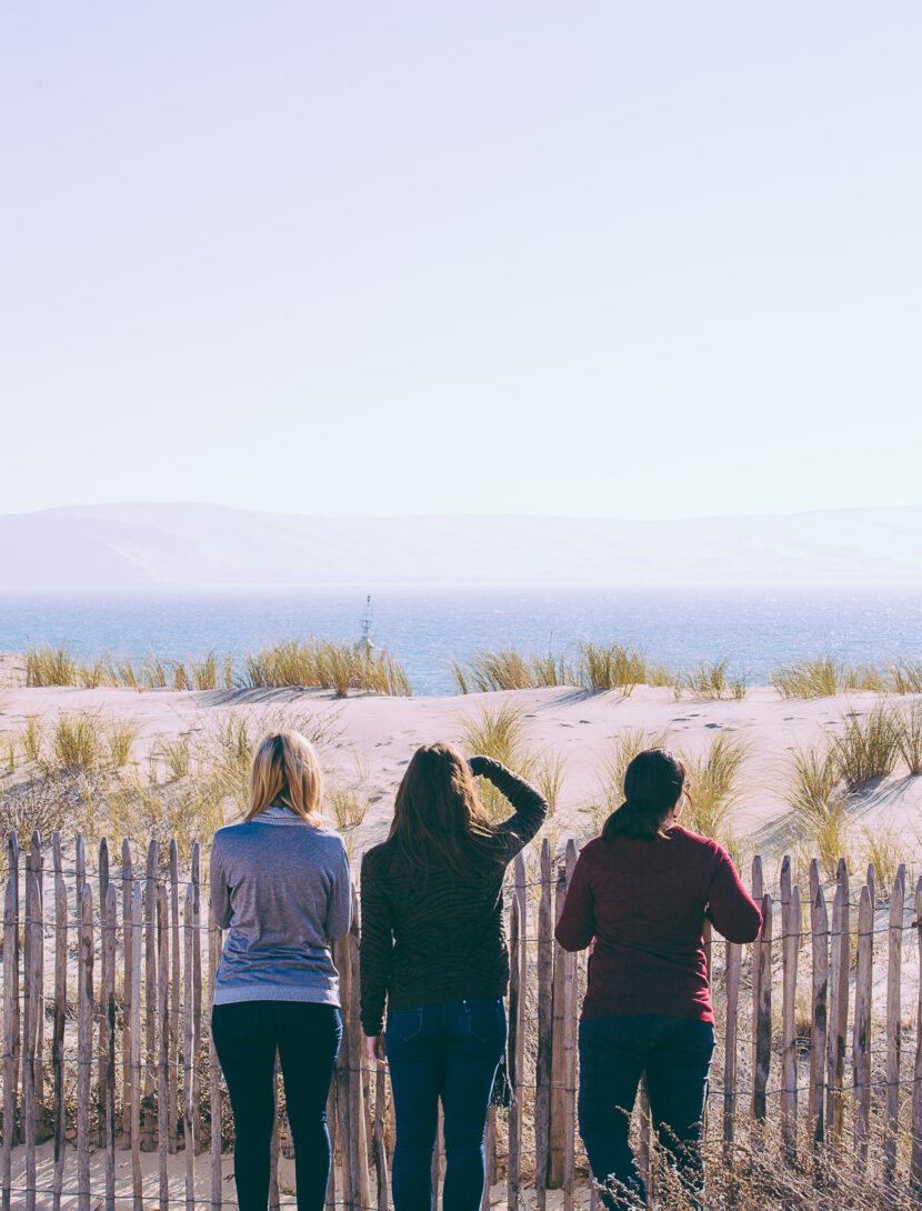 Trois femmes regardent l'horizon à la pointe.