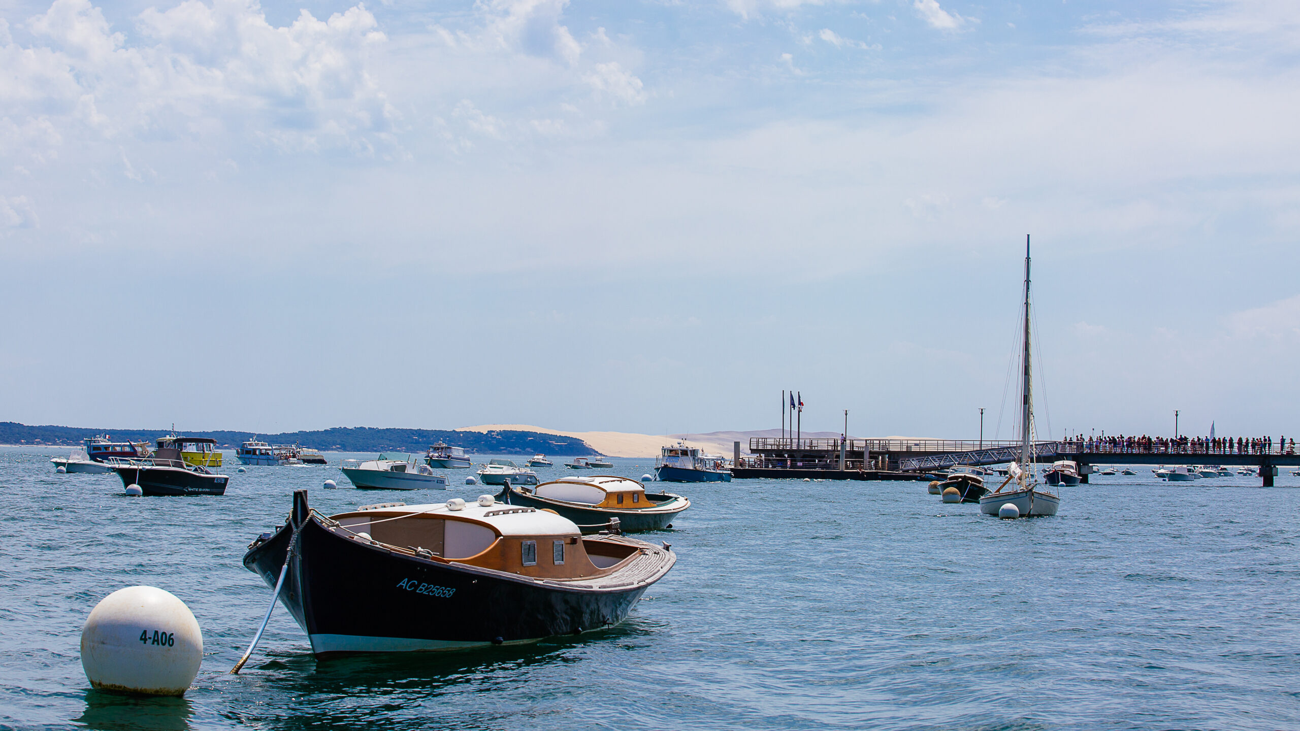 Vue sur le Bassin, avec une pinasse et la Dune du Pilat au loin.