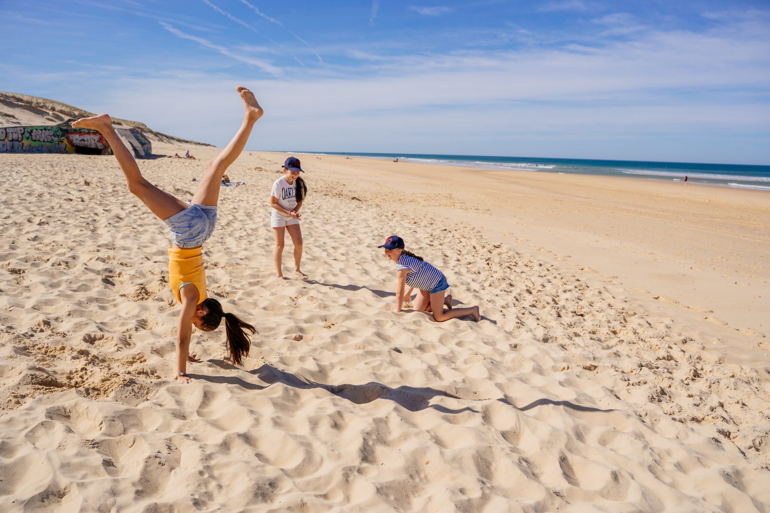 Des enfants s'amusent sur la plage océane de l'horizon du Cap Ferret.