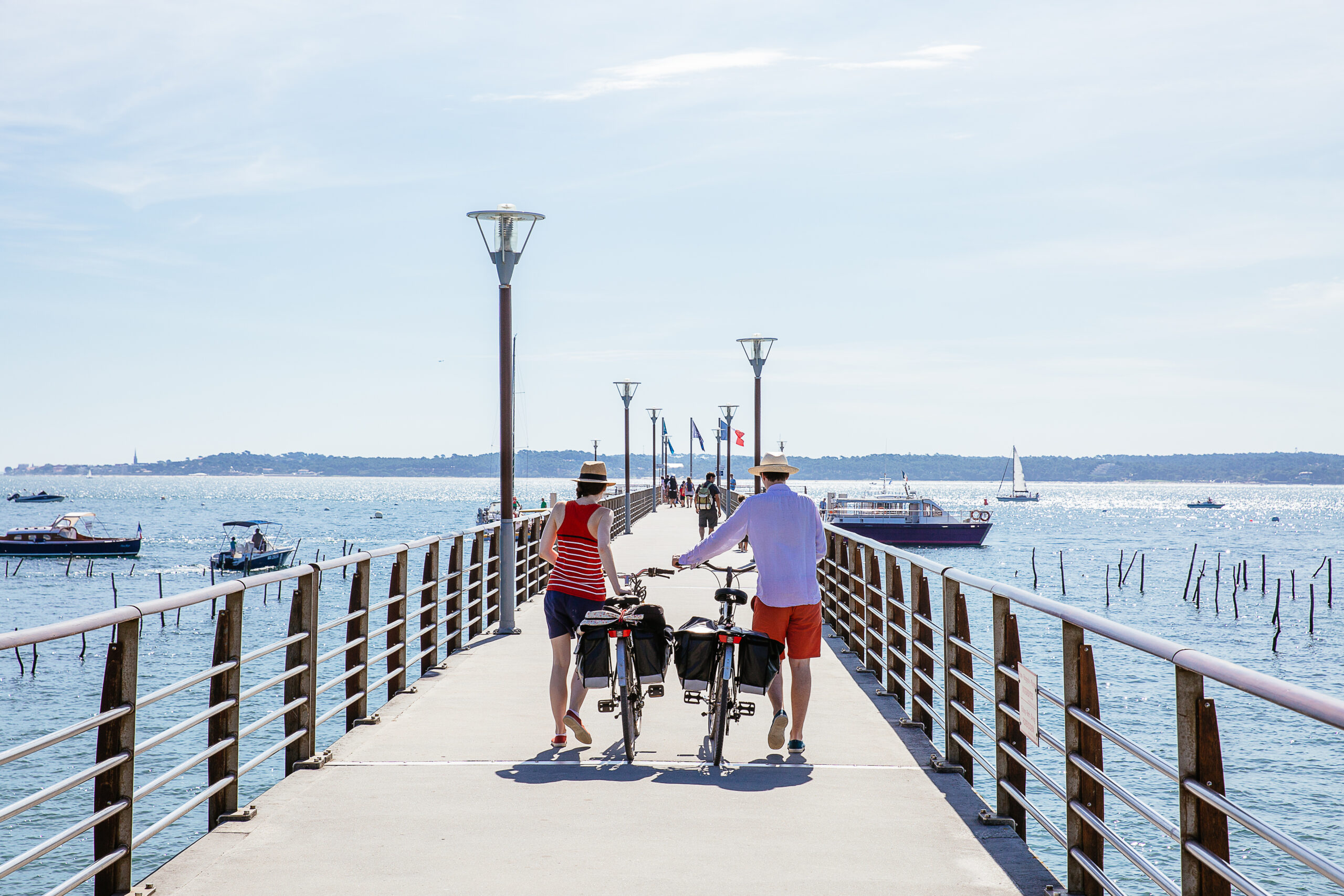 Se promener à pied avec les vélos à côté, le long du port, pour prendre les bateaux et traverser le bassin