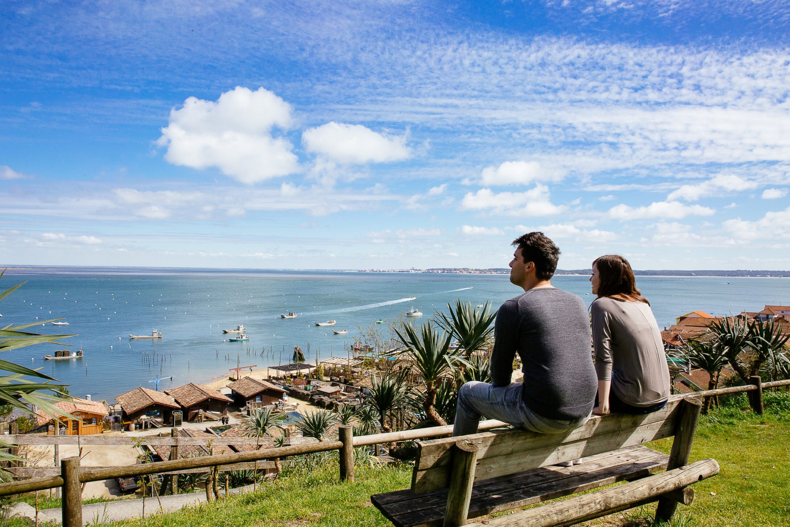 Un couple est posé sur un banc en train de regarder le bassin.