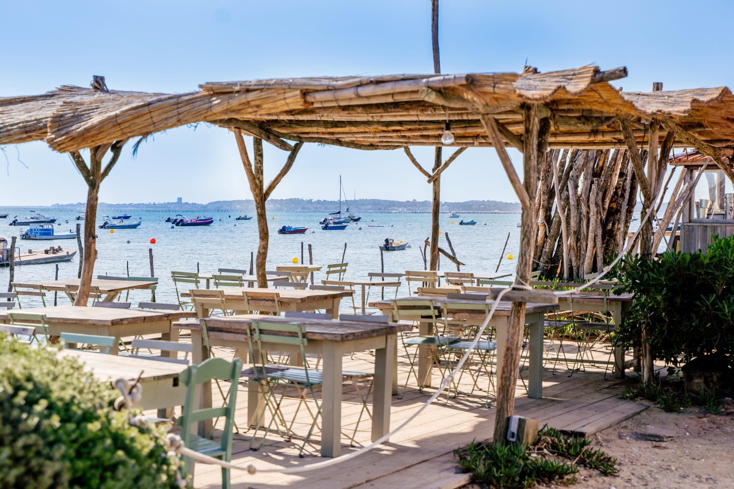 Terrasse d'un restaurant à l'herbe avec vue sur le bassin.