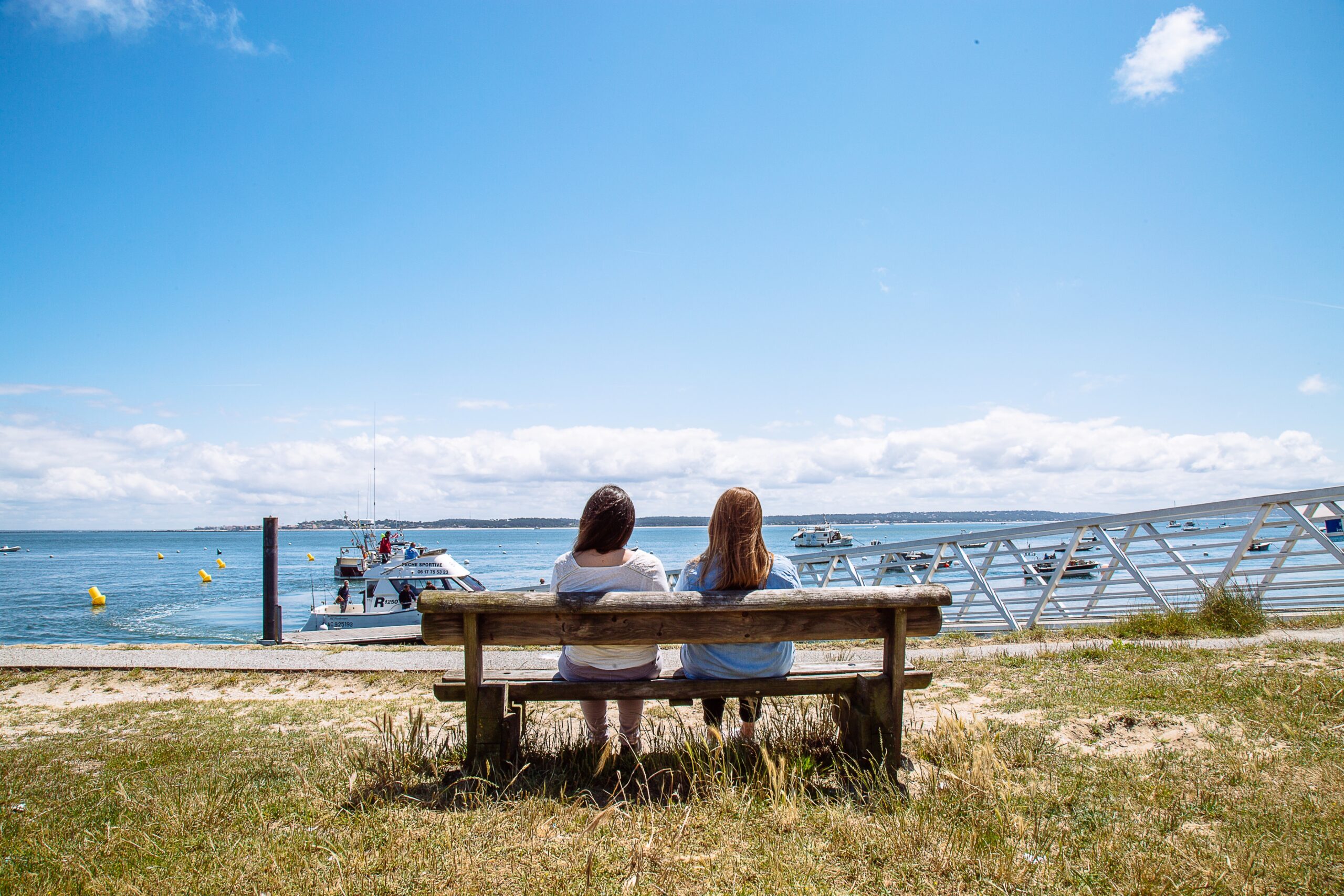 Deux femmes, assises sur un banc, contemplent le Bassin