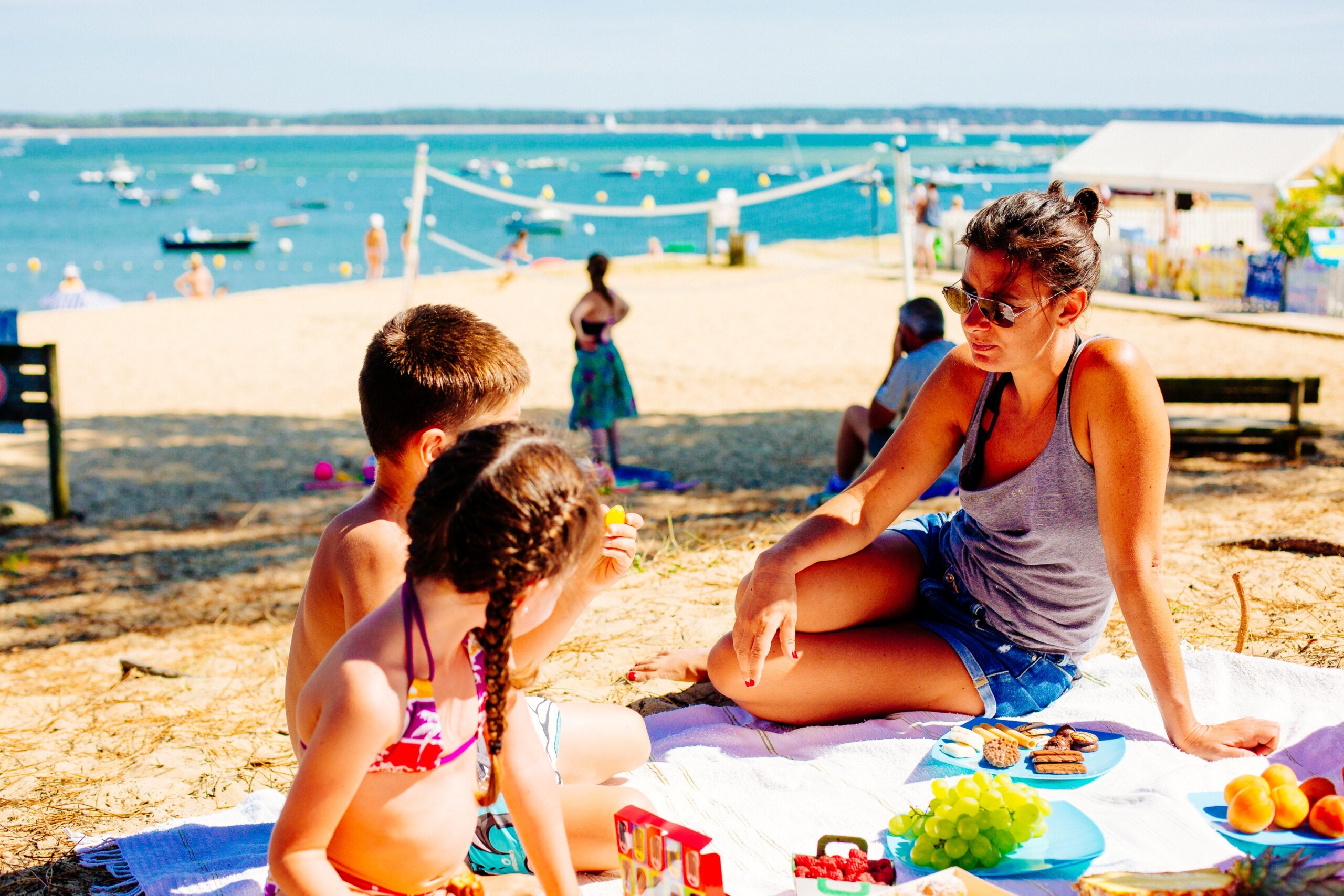 Une mère s'amuse avec ses enfants sur la plage.