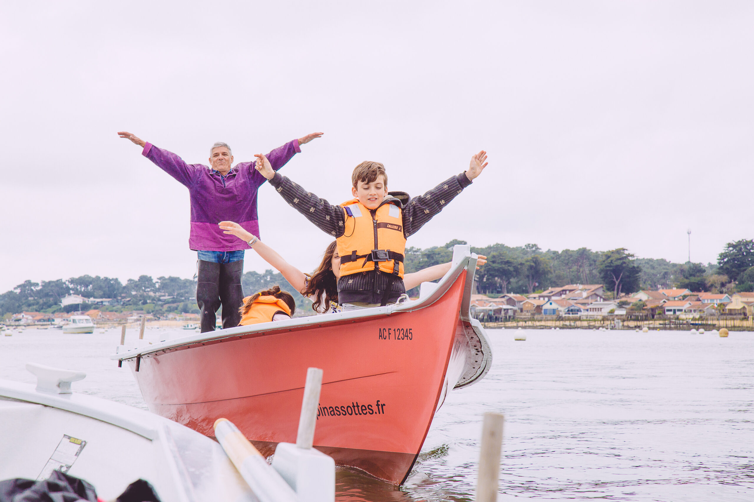 Des personnes s'amusent sur un bateau en reproduisant le célèbre signe du Titanic sur le Bassin.