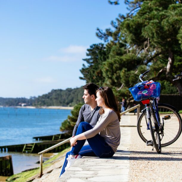 Un couple fait une pose de leur balade en vélo pour regarder le bassin.