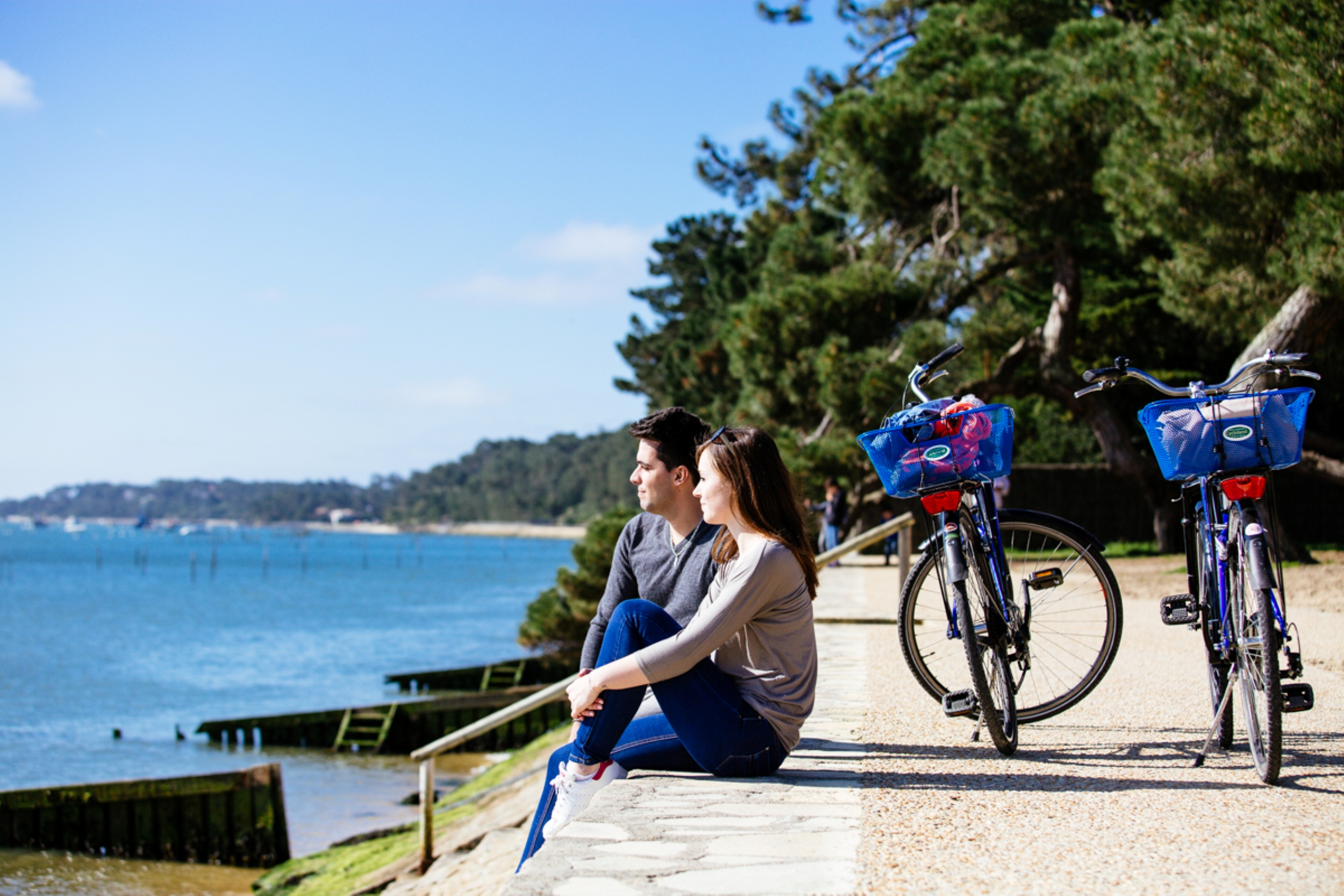 Un couple fait une pose de leur balade en vélo pour regarder le bassin.