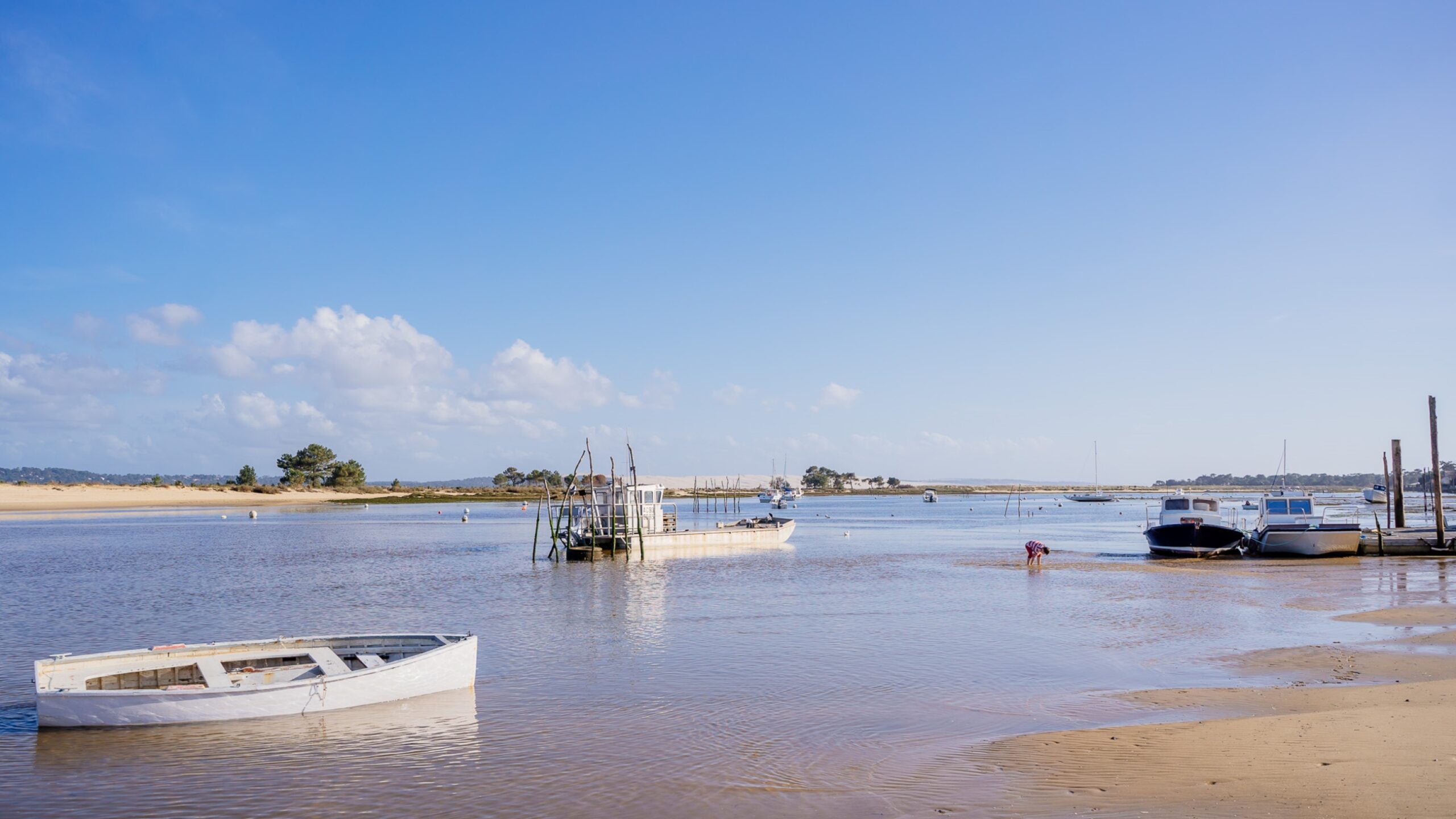 Vue sur la plage du Mimbeau avec le bassin et les bateaux de pêche.