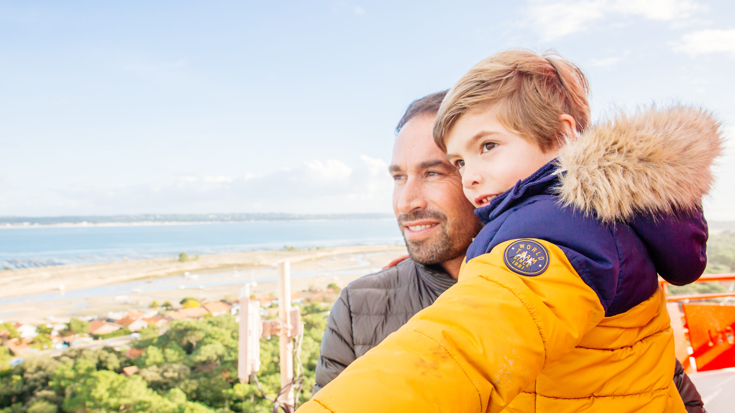 Un homme avec son enfant sont au sommet du Phare en hiver.