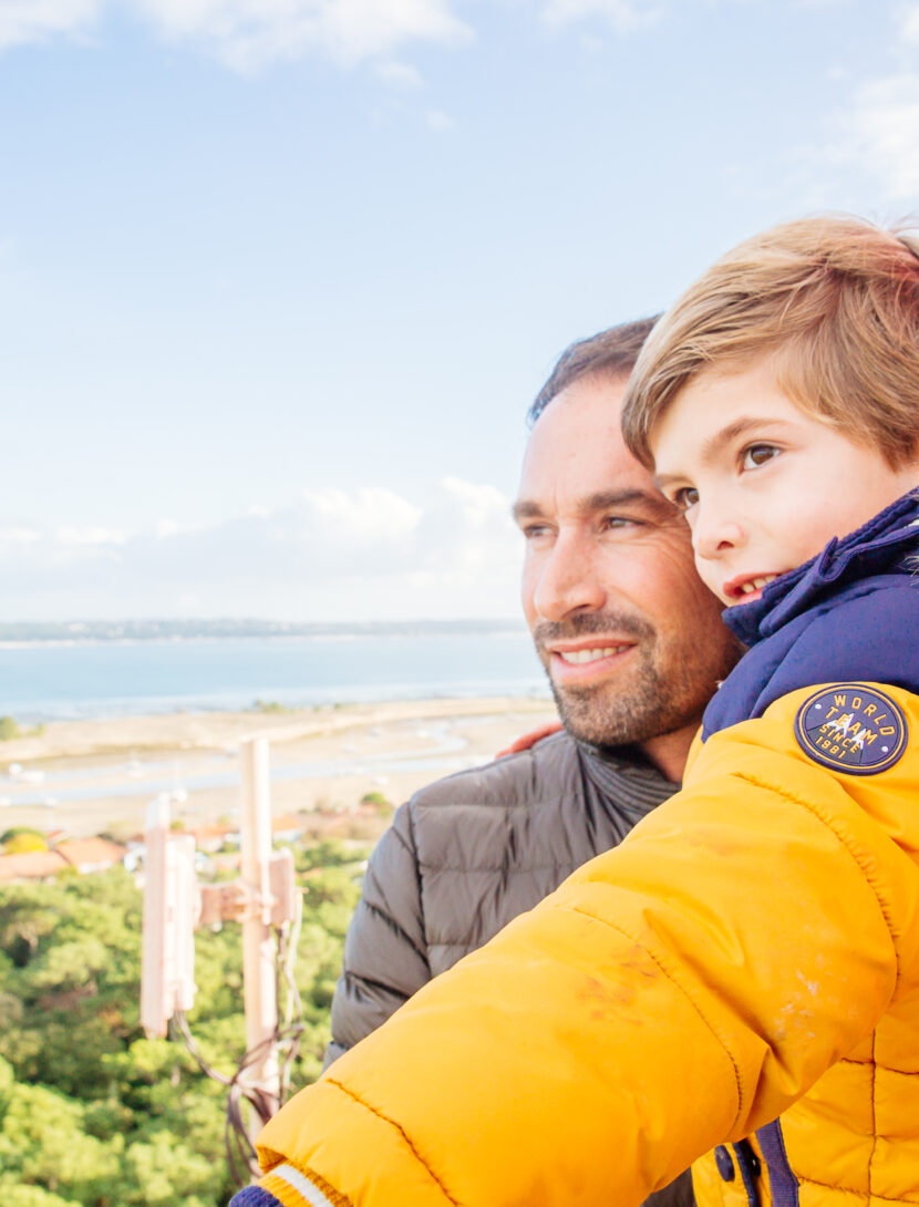 Un homme avec son enfant sont au sommet du Phare en hiver.