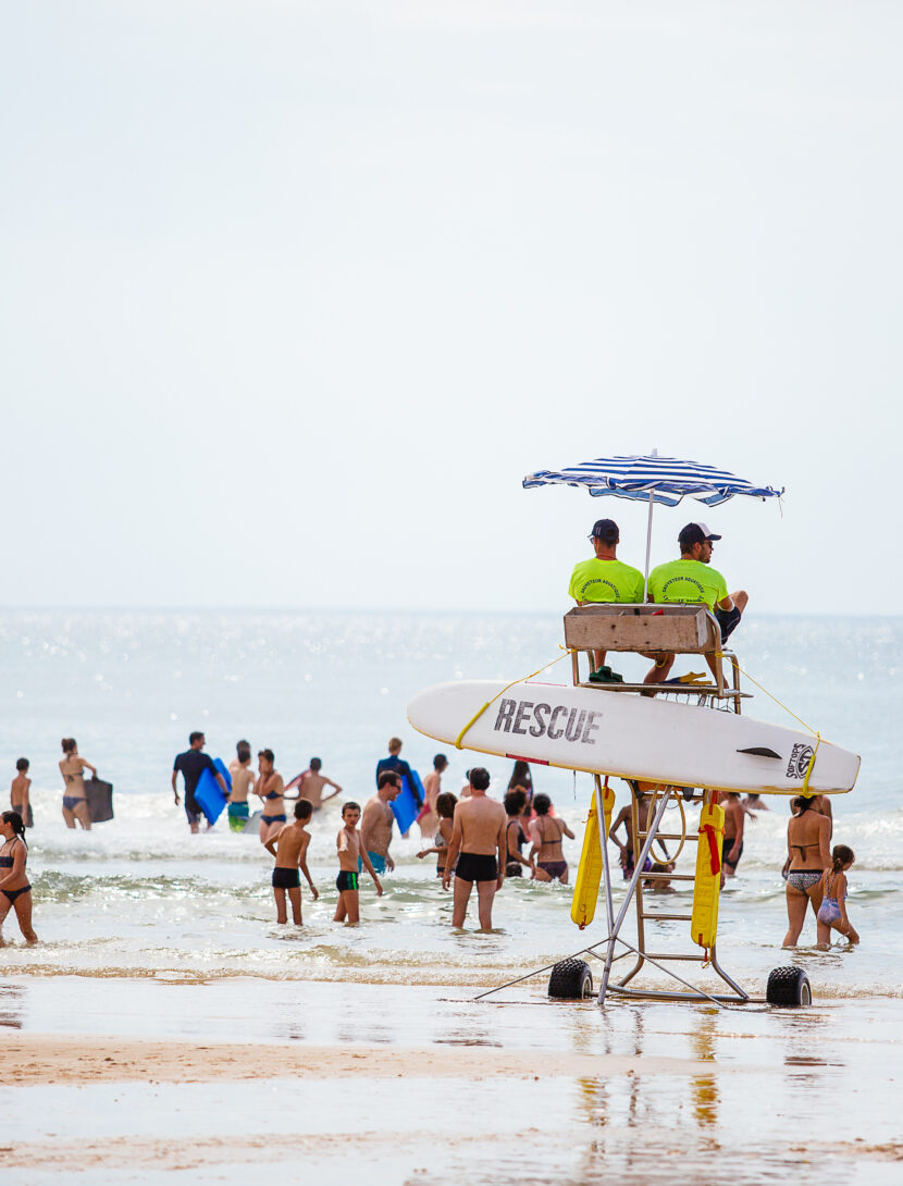 les maîtres nageurs sauveteurs sont en train de surveiller les gens dans l'eau sur leur chaise à hauteur.