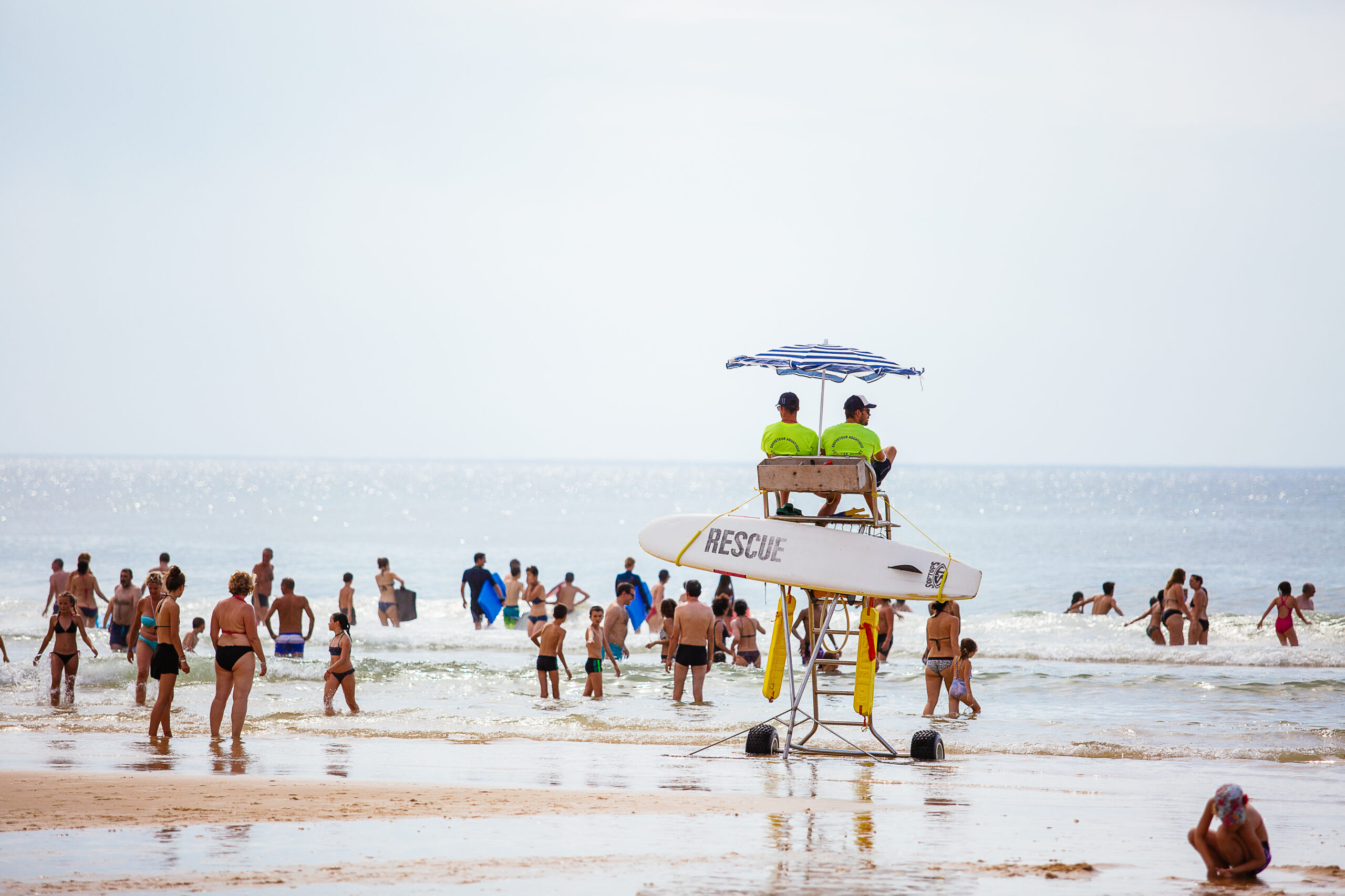les maîtres nageurs sauveteurs sont en train de surveiller les gens dans l'eau sur leur chaise à hauteur.