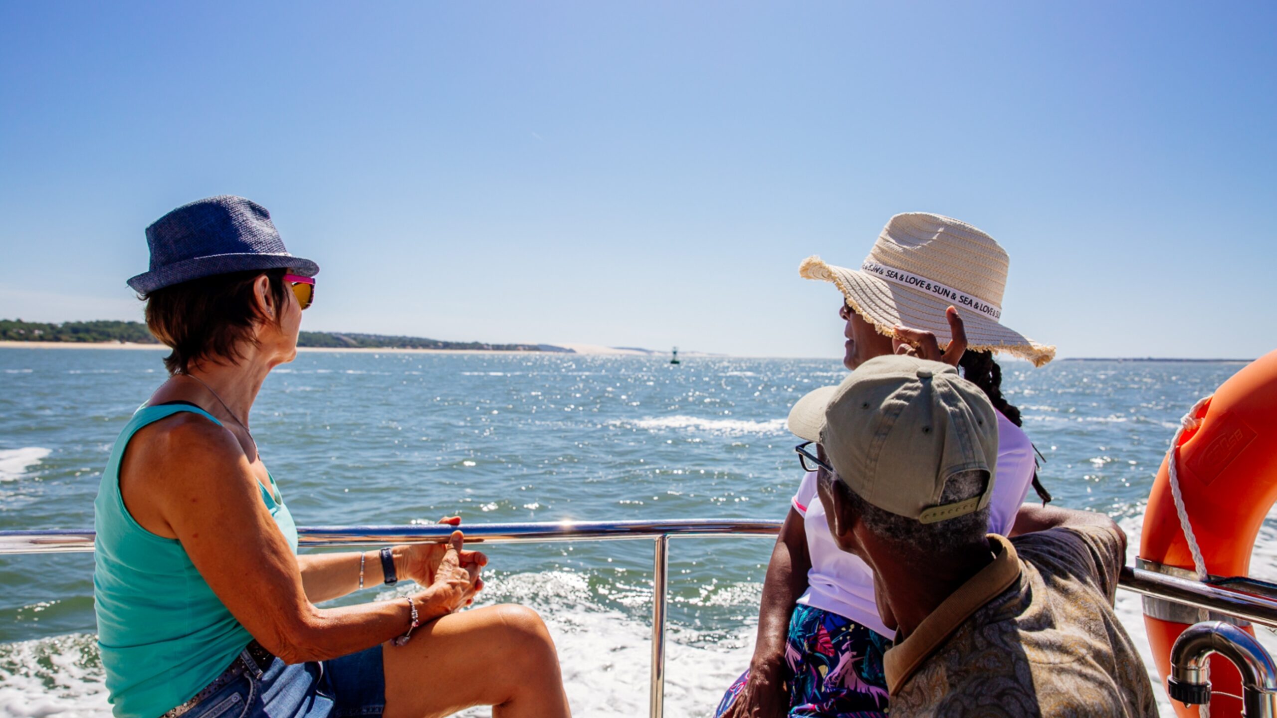 Groupe d’amis admirant le Bassin d’Arcachon depuis une navette sur l’eau.