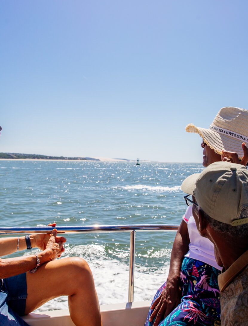 Groupe d’amis admirant le Bassin d’Arcachon depuis une navette sur l’eau.