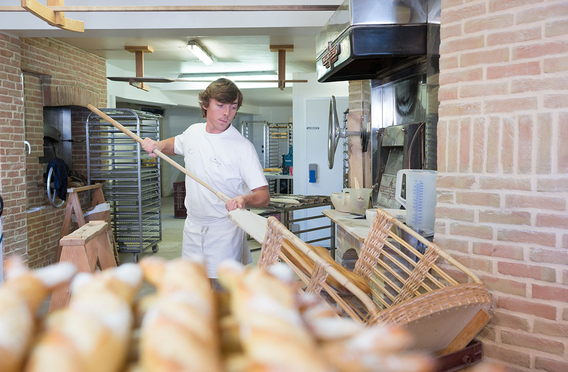 Un boulanger sort le pain du four à Lège-Cap Ferret.