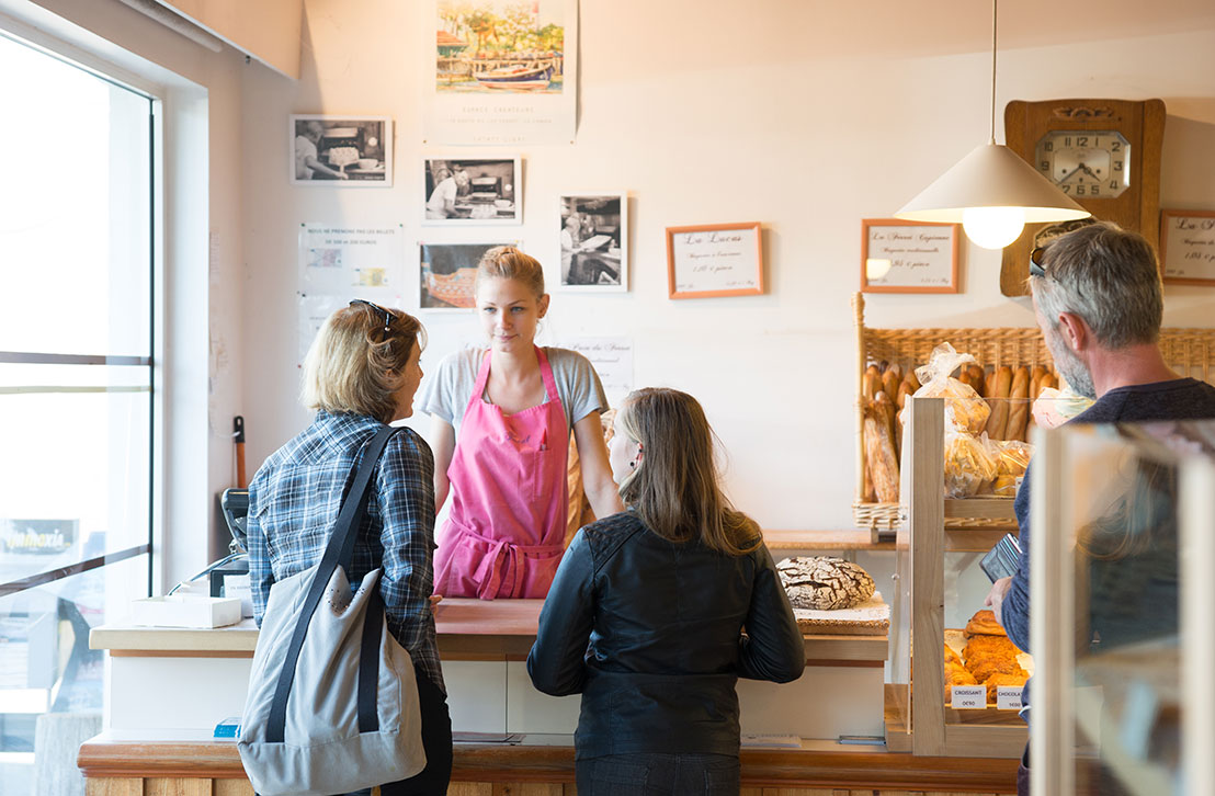 Une jeune femme sert des clients dans une boulangerie artisanale de Lège-Cap Ferret.