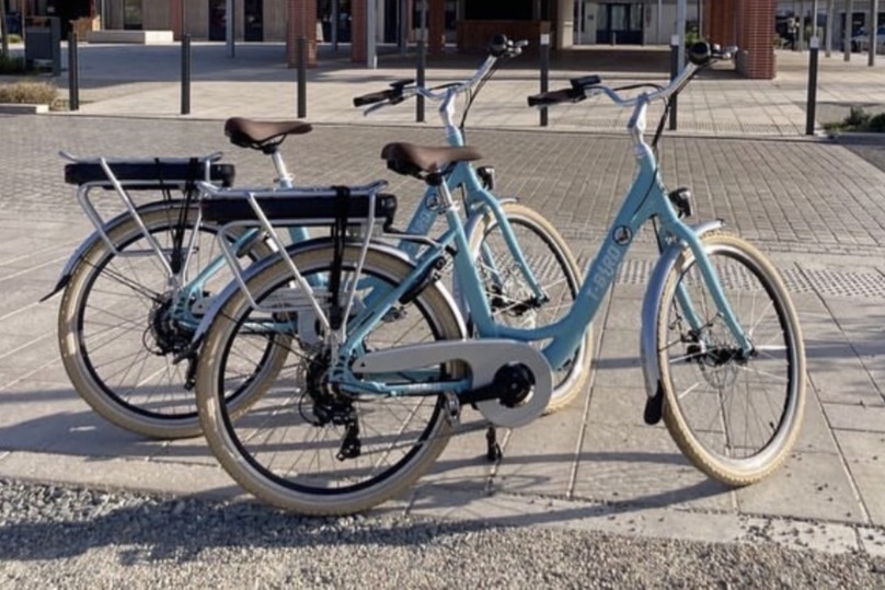 Deux vélos électriques sur un bord de rue.
