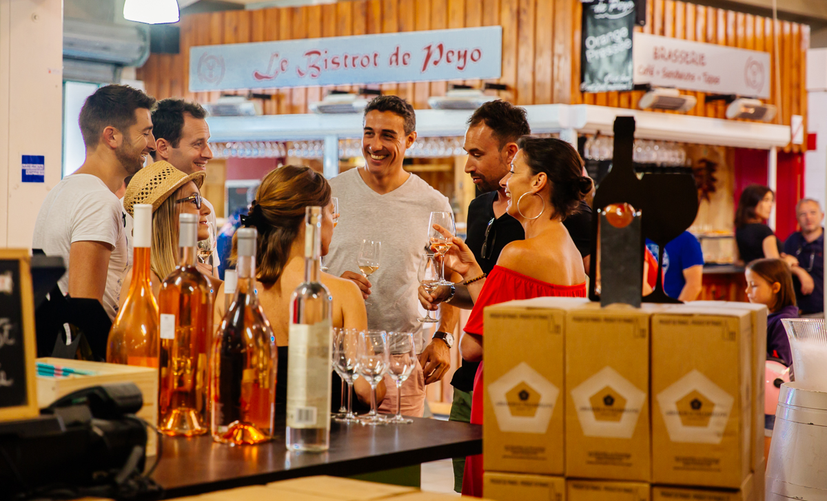 Un groupe d'amis qui boivent un verre dans le marché de Piraillan à Lège-Cap Ferret