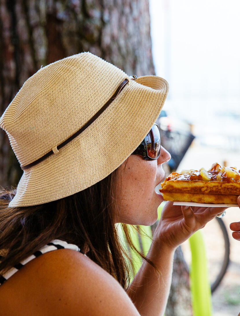 Femme dégustant une gaufre sur le port de Claouey à Lège-Cap Ferret